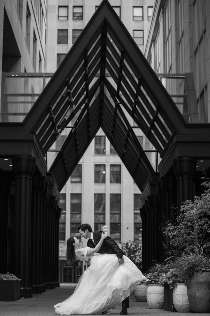 Couple holding each other in front of Shinola Hotel, a great wedding venue in Downtown Detroit, Michigan. 