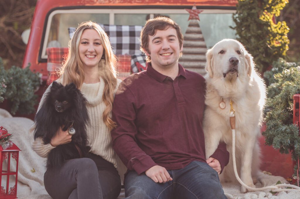 A Couple with their two dogs at a Red Truck Christmas Mini, at White Lake Michigan. 